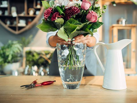 female florist puts flower bouquet into a vase 2021 08 26 16 26 51 utc 1 scaled